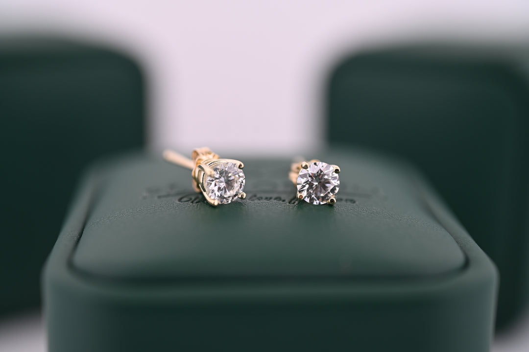 Cercei din aur cu diamante naturale "Selene" pentru femei, eleganți și rafinați, ideale ca cadou de lux, pe fundal verde.