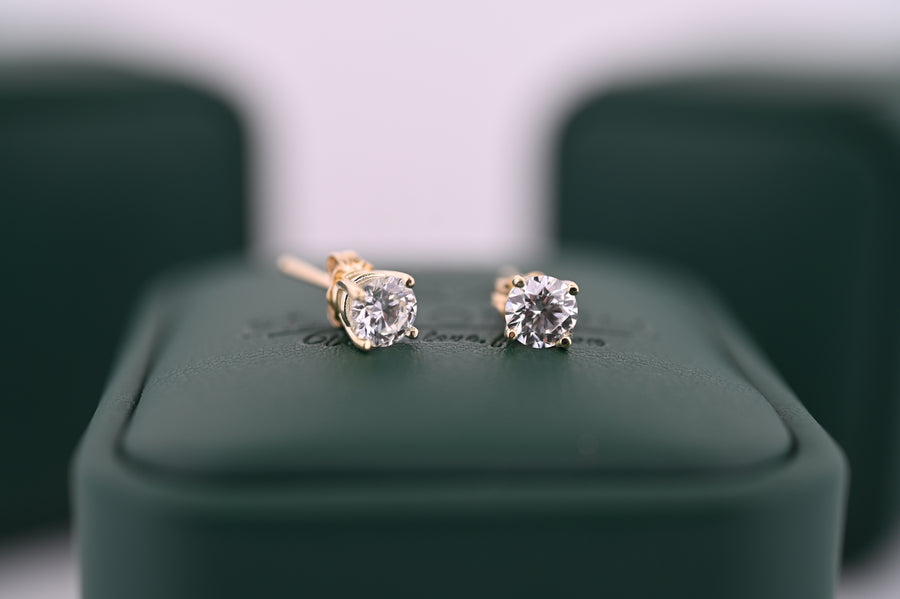 Cercei din aur cu diamante naturale "Selene" pentru femei, eleganți și rafinați, ideale ca cadou de lux, pe fundal verde.