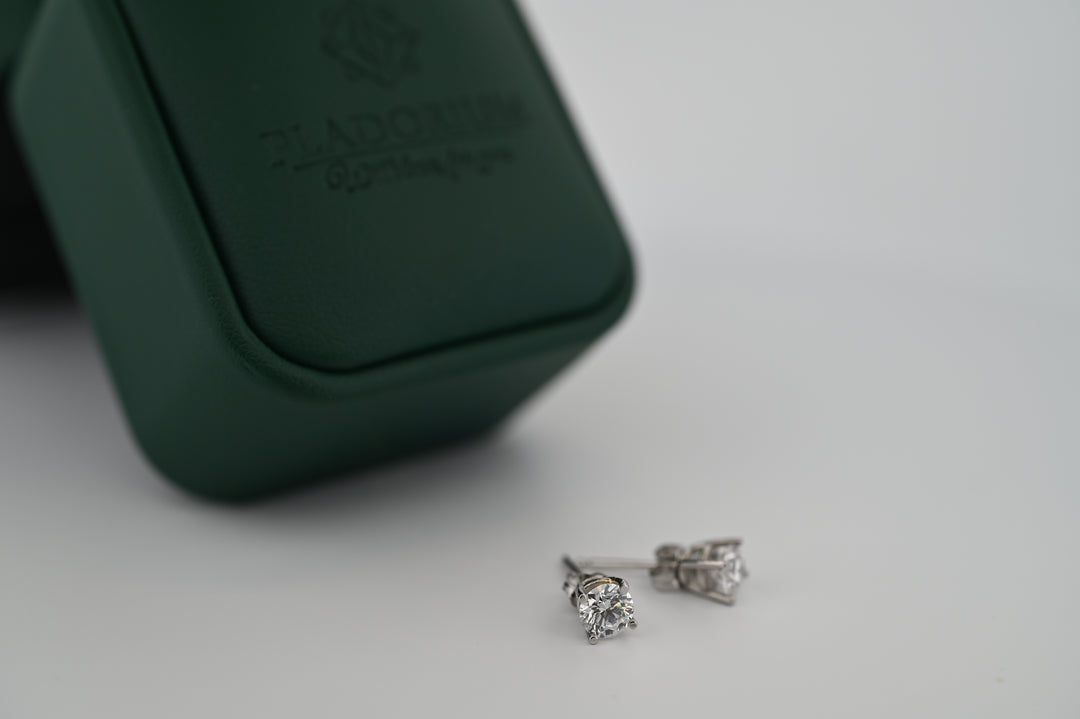 Cercei "Selene" din platină cu diamante naturale, expuși lângă o cutie elegantă, simbolizând luxul accesibil și rafinamentul suprem.