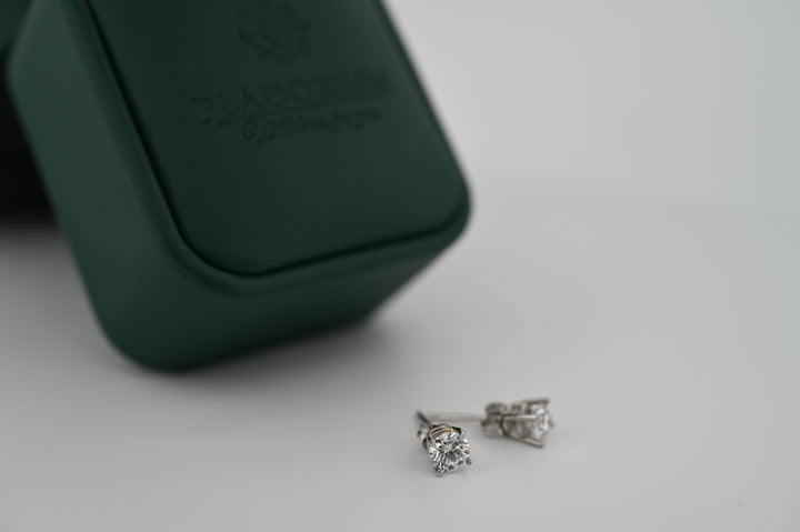 Cercei "Selene" din platină cu diamante naturale, expuși lângă o cutie elegantă, simbolizând luxul accesibil și rafinamentul suprem.