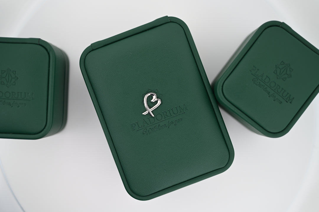 Cutie elegantă Pladorium verde cu sigla pentru bijuterii premium, inclusiv cercei din platină Eros, cadouri perfecte pentru femei.