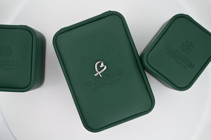 Cutie elegantă Pladorium verde cu sigla pentru bijuterii premium, inclusiv cercei din platină Eros, cadouri perfecte pentru femei.