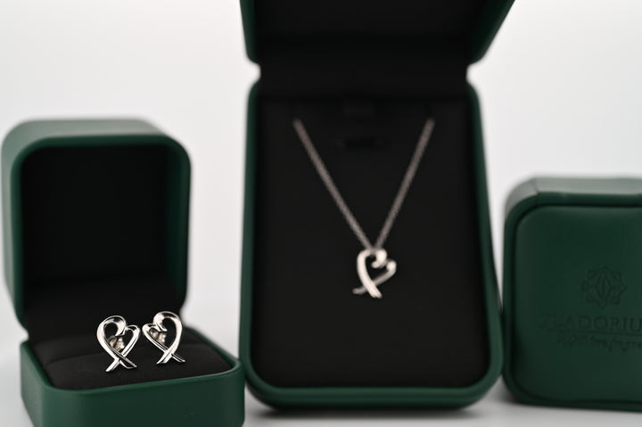 Set bijuterii elegant din platină cu pandantiv și cercei, design simbol al eternității, ambalat pentru cadou premium.