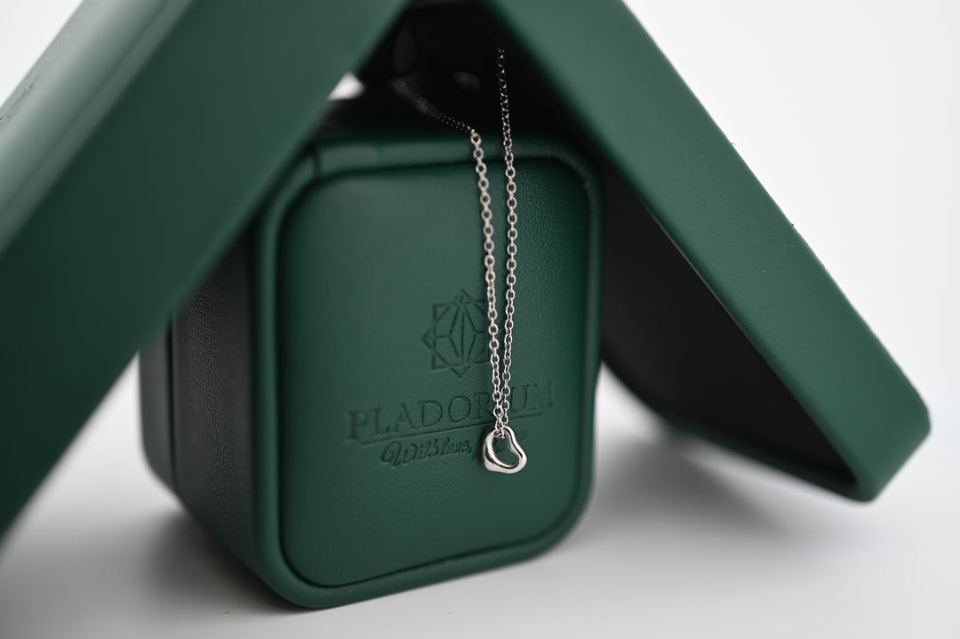Elegant pandantiv Hera din platină cu lănțișor, ambalat în cutie verde Pladorium, simbol al rafinamentului și durabilității.