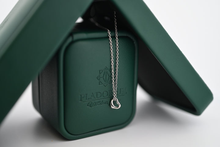 Elegant pandantiv Hera din platină cu lănțișor, ambalat în cutie verde Pladorium, simbol al rafinamentului și durabilității.